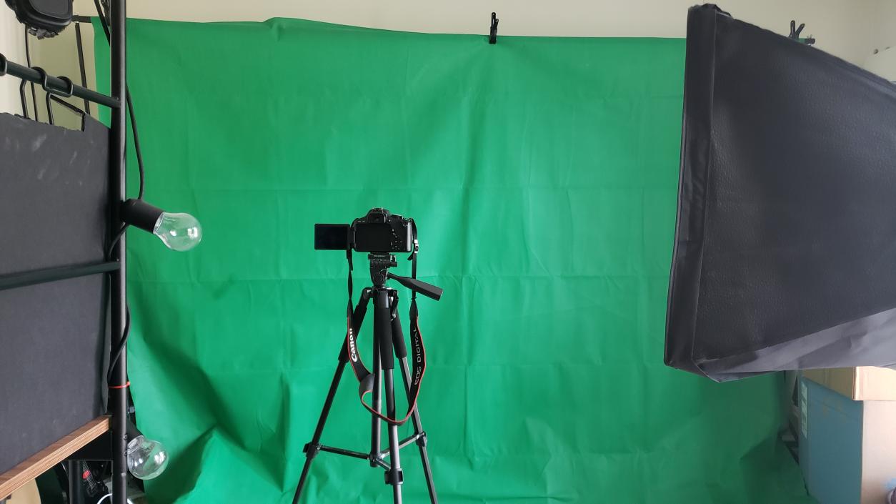 A DSLR camera and green screen and soft lights.